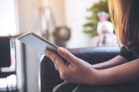 Closeup image of woman's hands holding and using tablet pc in cafeの写真素材