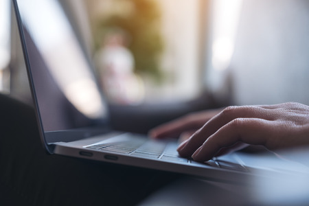 Closeup image of hands working and typing on laptop keyboard on the tableの写真素材