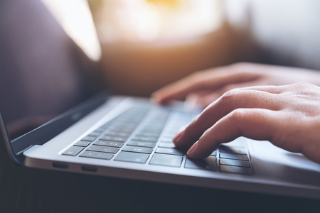 Closeup image of hands working and typing on laptop keyboard on the tableの写真素材