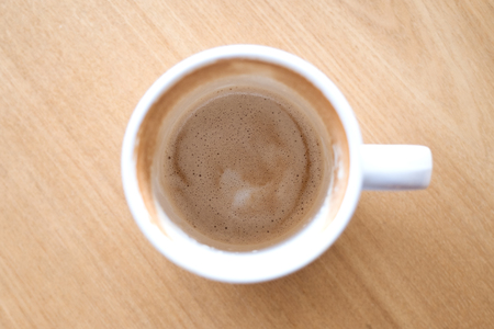 Top view image of finished cup of coffee on wooden table in cafeの写真素材