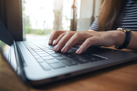 Closeup image of business woman working and typing on laptop keyboardの写真素材