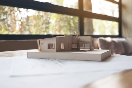 An architecture model with shop drawing paper on table in office の写真素材