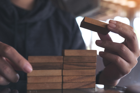 Closeup image of people playing and building wooden puzzle gameの写真素材