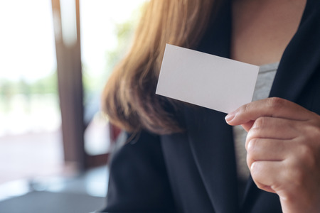 Photo pour A businesswoman holding and showing an empty business card  - image libre de droit