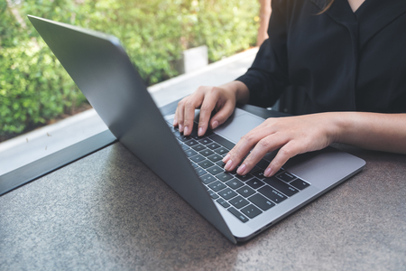 Closeup image of hands working and typing on laptop keyboard in officeの写真素材