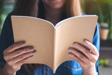 Closeup image of a woman reading a book in modern cafeの写真素材