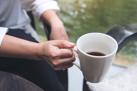 Closeup image of a woman holding a coffee cup before drinking in the morningの写真素材