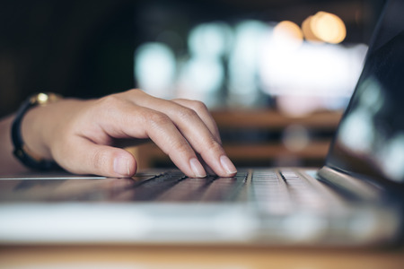 Closeup image of a business woman's hands working and typing on laptop keyboard in officeの写真素材