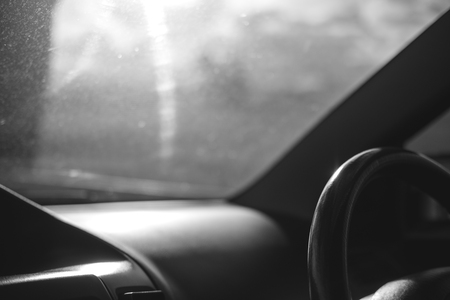 Black and white image steering wheel inside a car on the roadの写真素材