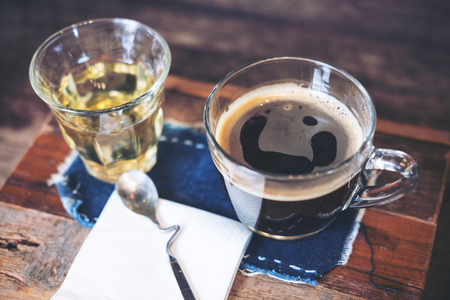Closeup image of cups of hot coffee and tea on vintage wooden table in cafeの写真素材