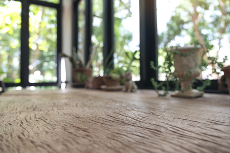 Closeup blur image of a wooden table with flowerpots in backgroundの写真素材