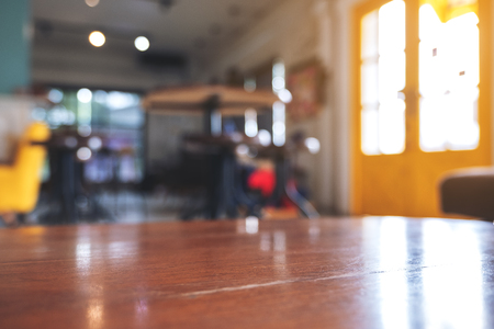 Wooden table in modern cafe with blur bokeh vintage backgroundの写真素材