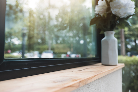 Closeup image of a wooden bar with flowerpots with blur green nature backgroundの写真素材