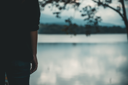 Closeup image of a woman standing alone by the river with blur backgroundの写真素材