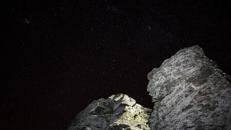 Night sky with rocks lightened upの写真素材