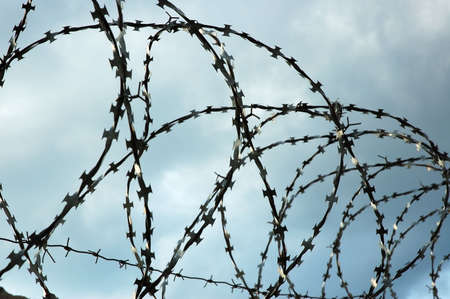 Barbed wire and cloudy skyの写真素材