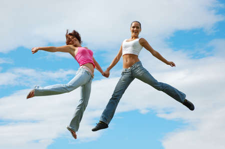 Jumping girls on sky backgroundの写真素材