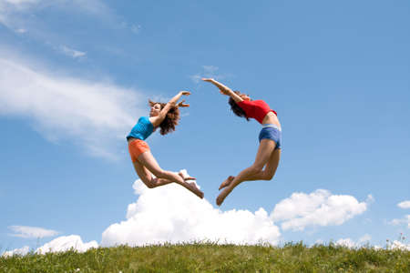 Jumping girls on meadowの写真素材