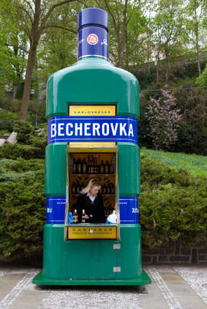 KARLOVY VARY, CZECH REPUBLIC - MAY 4, 2010: Woman selling famous Czech beverage Becherovka .Becherovka  is an herbal bitters made in Karlovy Vary by Jan Becher. It is flavored with anise seed, cinnamon, and approximately 32 other herbs.  May 4 , 2010 in Kのeditorial素材