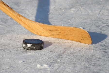 hockey stick and puck on the ice の写真素材