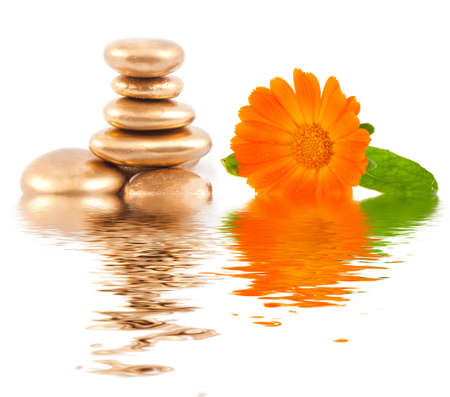 Golden spa stone and calendula flowers の写真素材