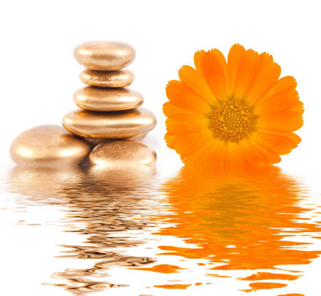 Golden spa stone and calendula flowersの写真素材
