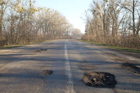 Bad road in holes after winter in Ukraine.の写真素材