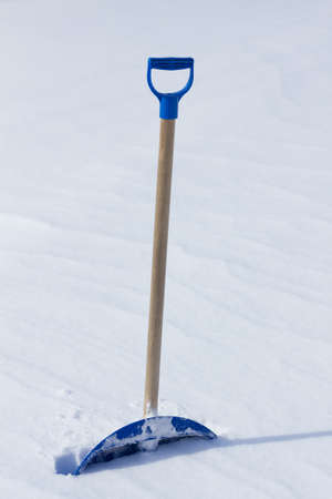 Snow shovel standing in the snowの写真素材