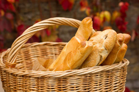 Fresh bread in the basket on a background autumn leavesの写真素材