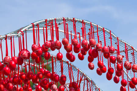 Arch of red Easter eggs hanging on ribbonsの写真素材