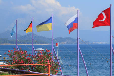 Flags of Turkey, Russia, Ukraine, Germany and Kazakhstan on the beach in Kemer, Antalyaの写真素材