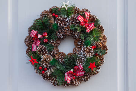 Christmas wreath with balls and ribbons on a white doorの写真素材