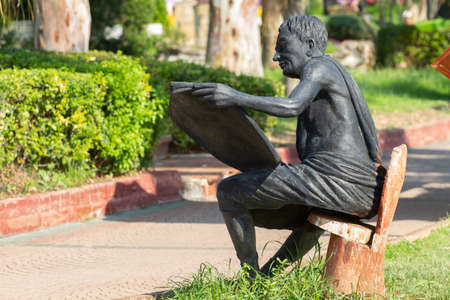 Kemer, Turkey - June 21, 2018:Statue of a man reading a newspaper on the promenade in Kemer, Turkeyのeditorial素材