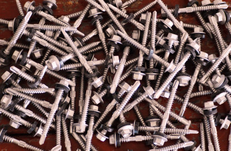 Screws piled up together in a factory, closeup of photoの写真素材