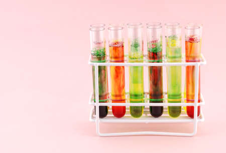 Test tubes with liquid of various colors on a pink backgroundの写真素材