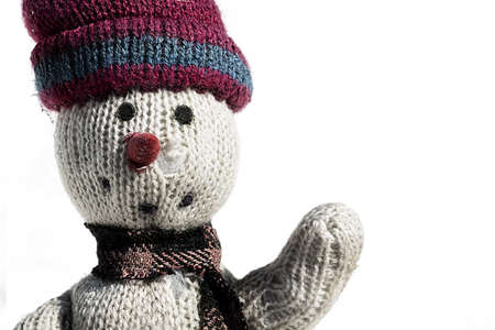 old rag doll in the snow with a red heart on white backgroundの写真素材