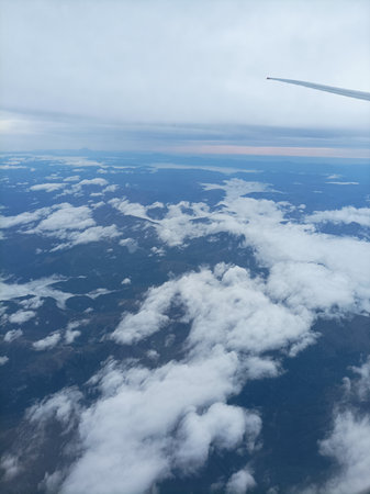 Clouds as seen through window of an aircraft flying above the earthの写真素材