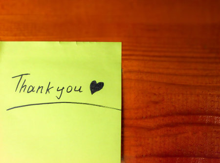 Thank you handwritten, on yellow paper, with a heart symbolの写真素材