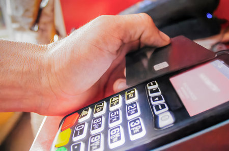A man pays in a store with a bank card through a contactless terminalの写真素材