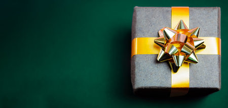 Christmas gift with a beautiful bow on a green backgroundの写真素材