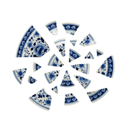 A collection of broken porcelain plate pieces, featuring intricate blue and white patterns, meticulously arranged in a dynamic scattered composition against a clean white surface.の素材