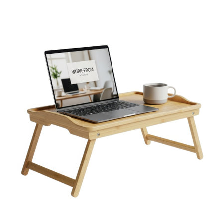 A wooden laptop bed tray table is set up for a comfortable work session, featuring a laptop displaying an interior design scene and a steaming coffee mug.の素材