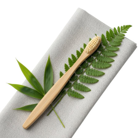 A sustainable bamboo toothbrush lies elegantly on a textured cloth, accented by lush green fern and bamboo foliage. This image evokes a sense of natural care and eco-conscious living.の素材