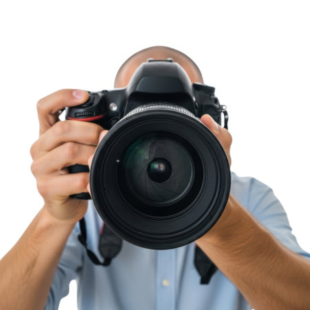 A person is holding a large camera in front of their face, capturing a shot. Isolated on white background.の素材