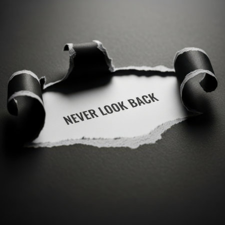 A piece of torn paper with the words Never Look Back is dramatically revealed against a dark background.の素材