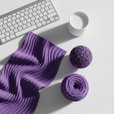 A clean and organized desk scene featuring a modern keyboard, a cup of liquid, and stylish purple textile items, suggesting a focus on work and relaxation.の素材