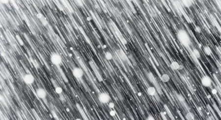 A monochromatic, abstract image depicting the dynamic motion of falling snow against blurred, streaking lines.の素材