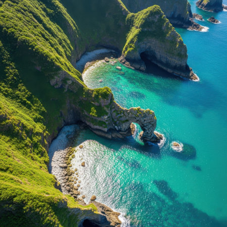 Experience the breathtaking beauty of nature from above. This aerial perspective showcases dramatic green cliffs, pristine beaches, and crystal-clear turquoise waters. A perfect scene of coastal serenity and natural wonder.の素材
