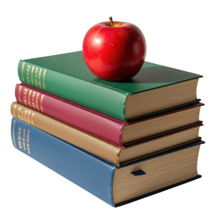 A vibrant red apple rests atop a pile of four distinct hardcover books, all presented on a clean white background.の素材