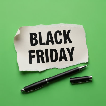 A torn piece of paper with "BLACK FRIDAY" printed in bold black letters, accompanied by a sleek black pen and its cap, presented against a vibrant green backdrop. This visual highlights a significant retail event.の素材